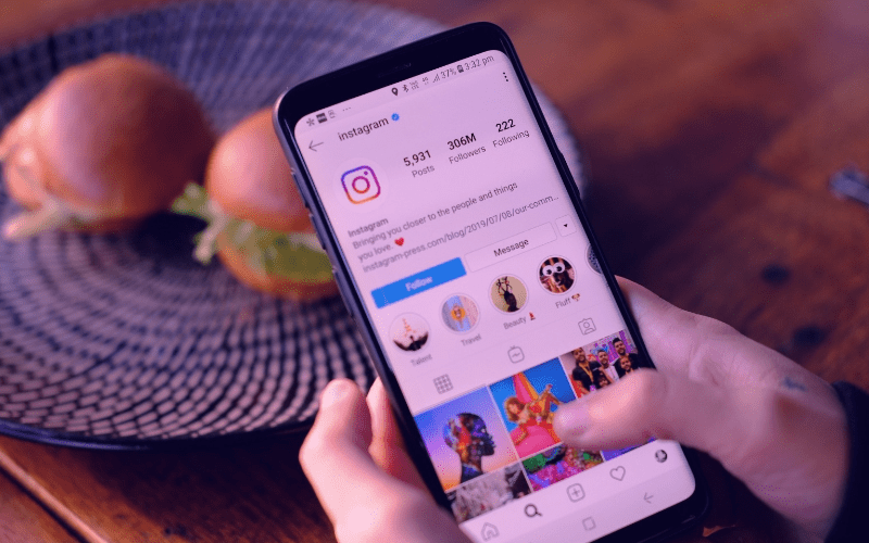 Person using Instagram on mobile phone, browsing through photos and videos on the app